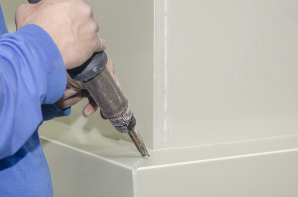 Technician performing hot-air plastic welding